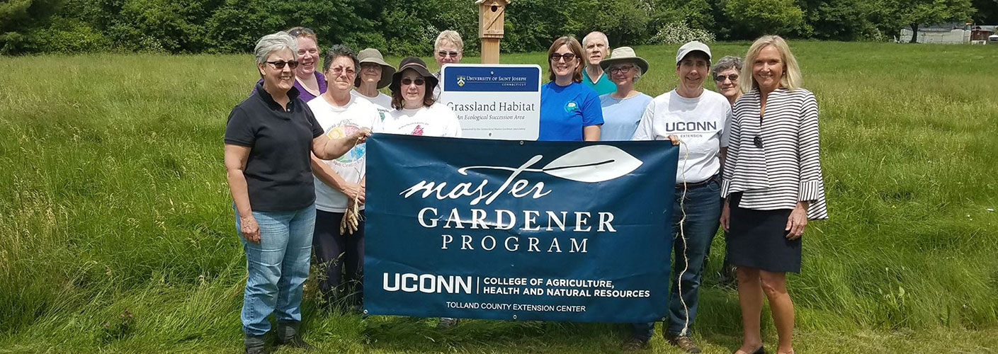 group of people holding Master Gardener banner and smiling